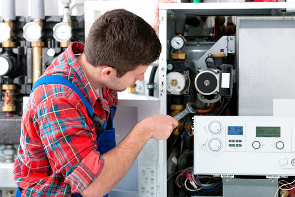 HVAC technician inspecting and repairing boiler controls in Orem