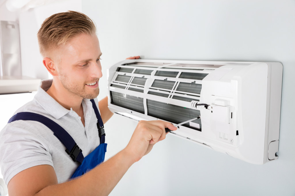 HVAC technician performing ductless air conditioning maintenance in Orem