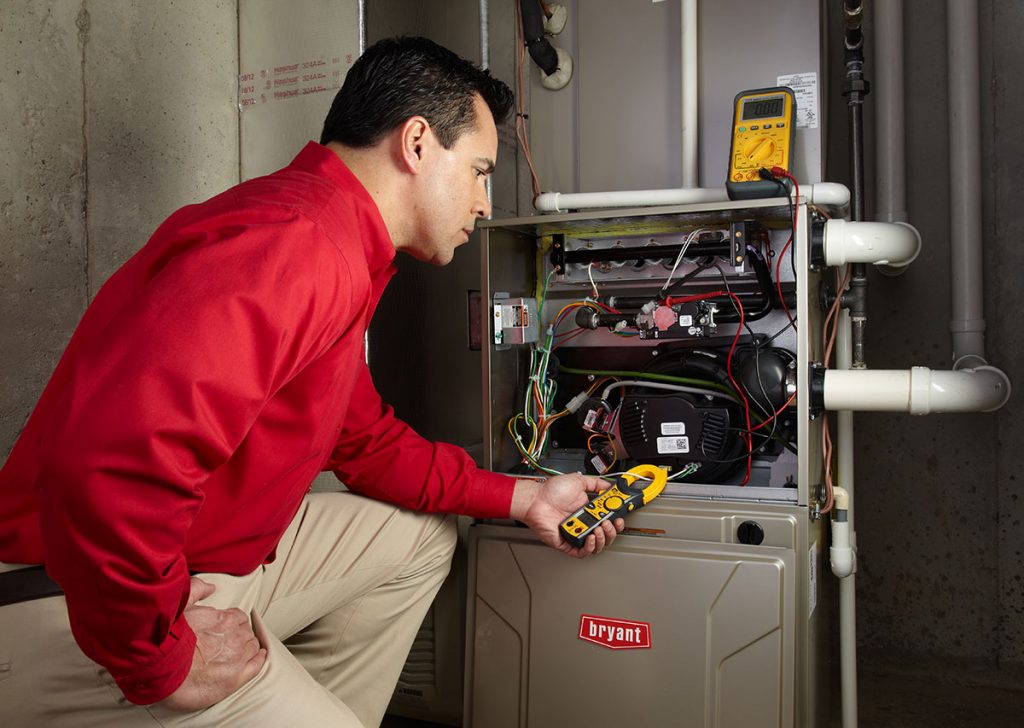 HVAC technician repairing an indoor furnace in Orem