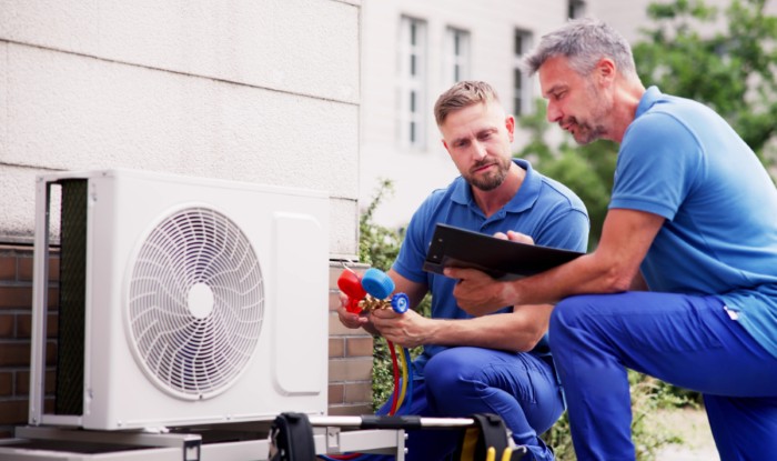 HVAC technicians installing an outdoor air conditioning unit in Orem