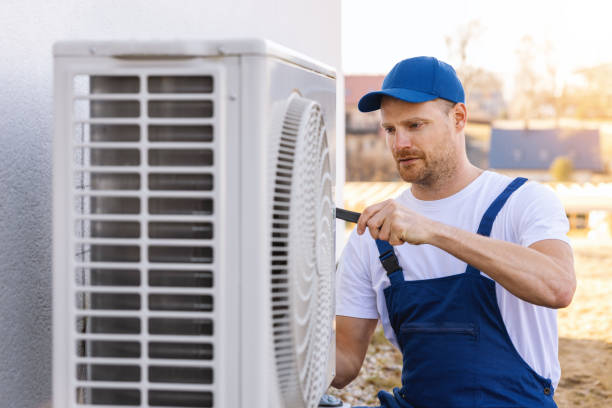 HVAC technician servicing an outdoor air conditioning unit in Orem