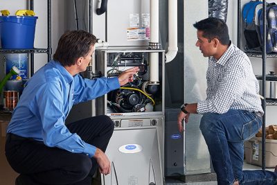 65df8c11f3e4c468cbd351a5_furnace repair vs replacement – Copy HVAC technician explaining furnace repair and maintenance to a homeowner in Orem, UT