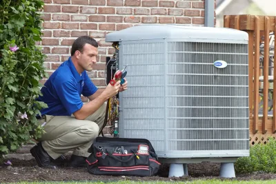 design-air-heating-and-air-conditioning-decatur-il-05 – Copy HVAC technician inspecting an outdoor air conditioning unit in Orem, UT