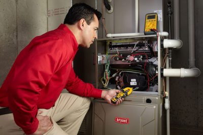 furnace repair Heating and air conditioning technician servicing an indoor furnace in Orem, UT
